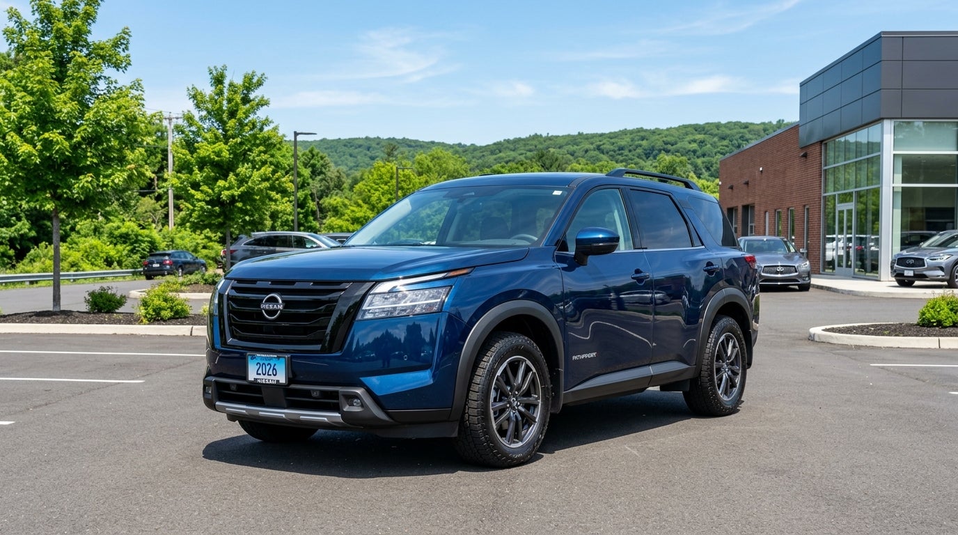 A blue Nissan Pathfinder SUV parked in a dealership lot on a sunny day.