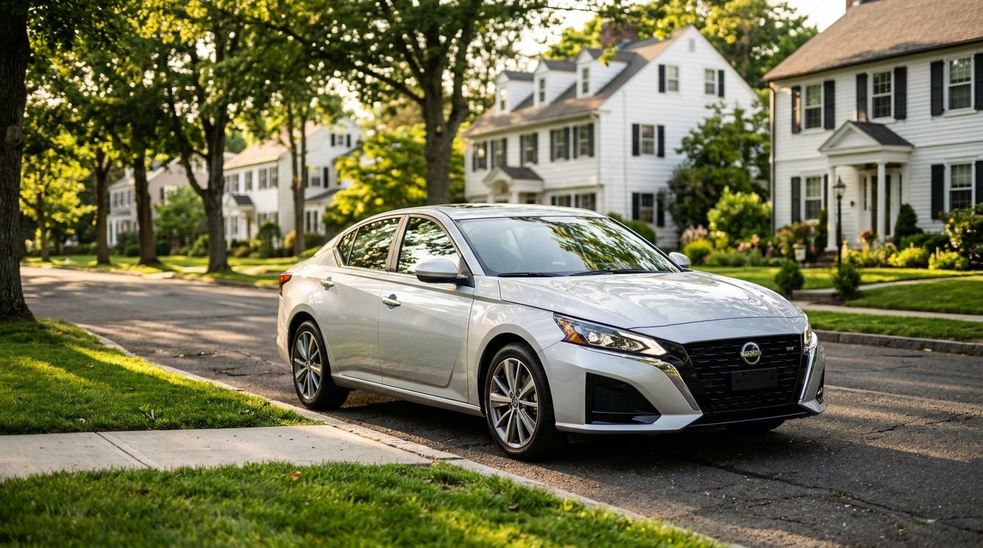 Silver Nissan sedan parked on a sunny, tree-lined suburban street in front of white houses. (Representative image for illustration purposes only. Actual vehicle may vary based on trim and configuration.)