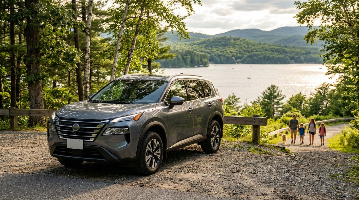 A gray SUV parked on a gravel overlook next to a scenic lake with a family walking a dog in the background. (Representative image for illustration purposes only. Actual vehicle may vary based on trim and configuration.)