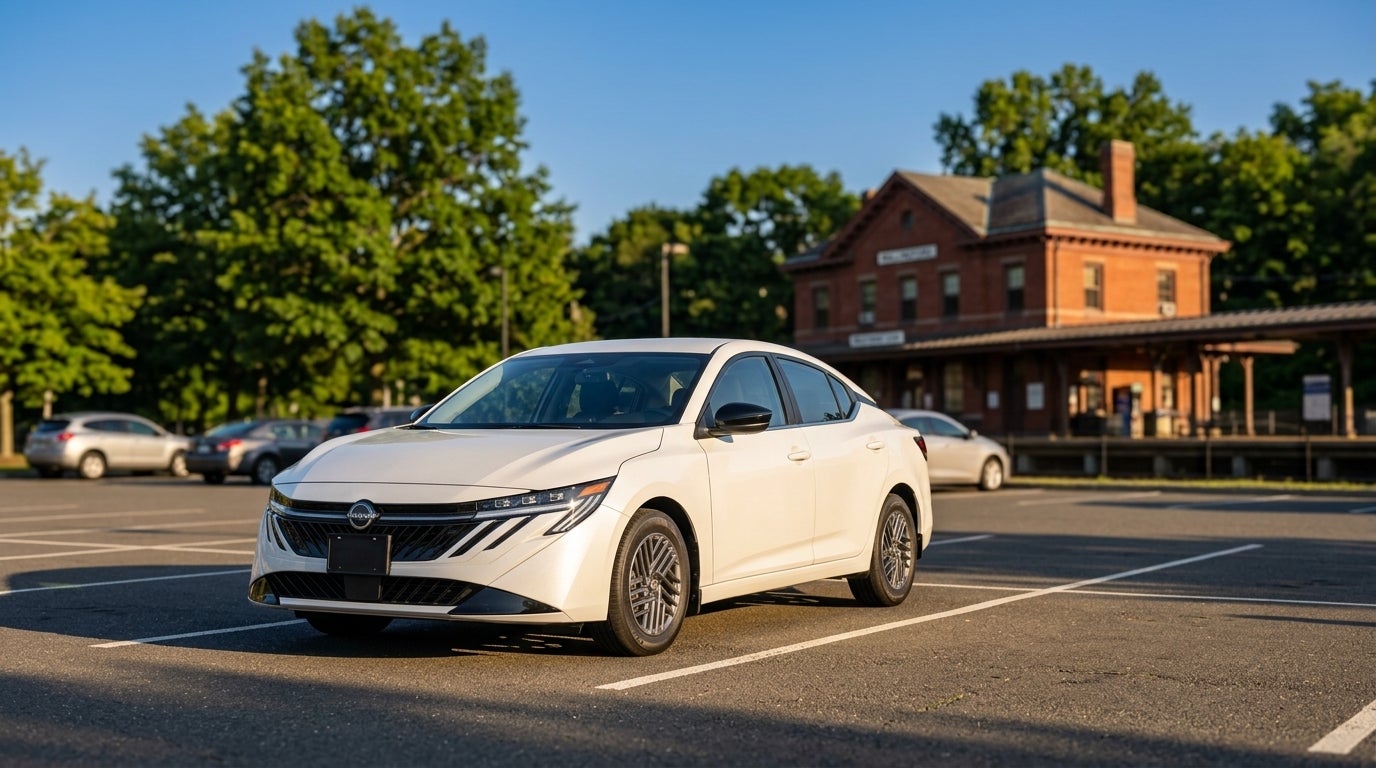 Front three-quarter view of a white sedan parked in an empty asphalt lot with a brick building in the background. (Representative image for illustration purposes only. Actual vehicle may vary based on trim and configuration.)