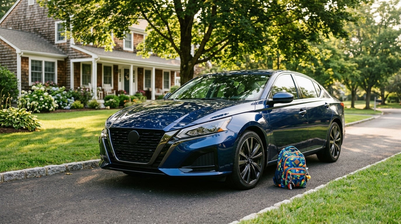 Dark blue sedan parked in a suburban driveway with a colorful school backpack resting on the asphalt beside it. (Representative image for illustration purposes only. Actual vehicle may vary based on trim and configuration.)
