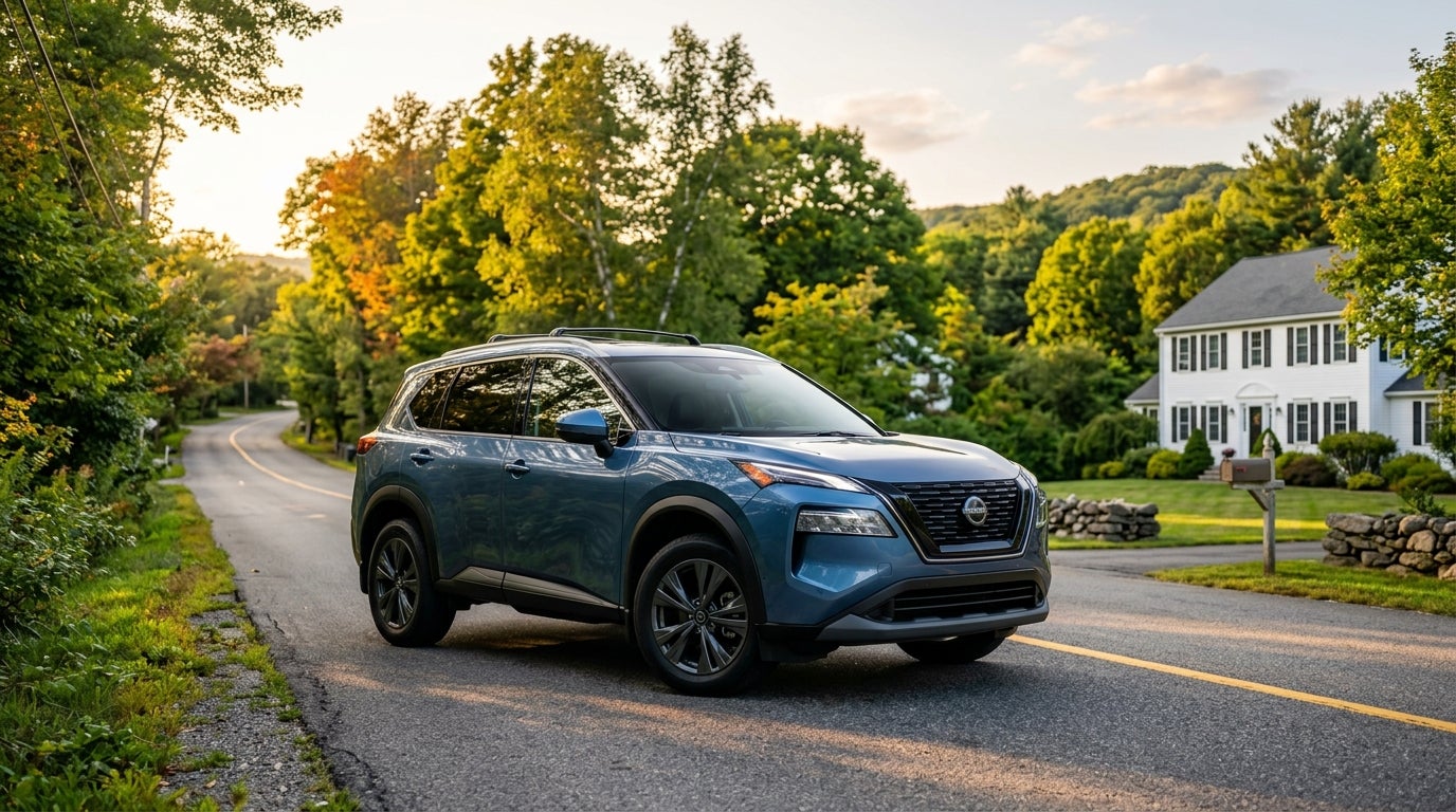 A blue Nissan Rogue SUV parked on a paved country road next to a white house during sunset. (Representative image for illustration purposes only. Actual vehicle may vary based on trim and configuration.)