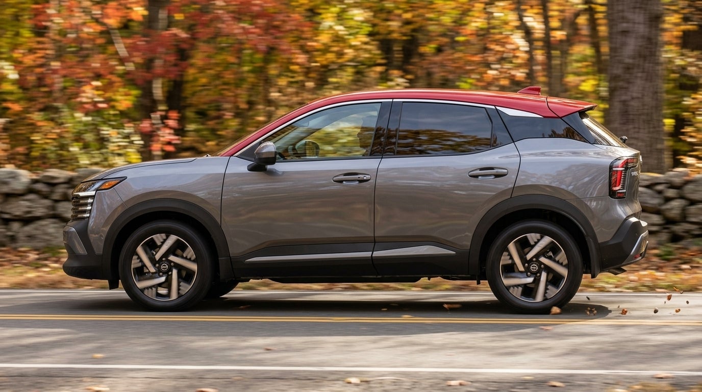 Side view of a grey and red two-tone compact SUV driving past autumn trees along a paved road. (Representative image for illustration purposes only. Actual vehicle may vary based on trim and configuration.)